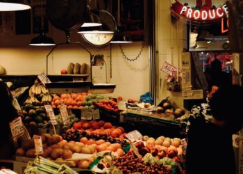 A fruit stand glows with neon signs.