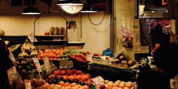 A fruit stand glows with neon signs.