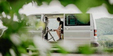 a woman sitting in the back of a white van