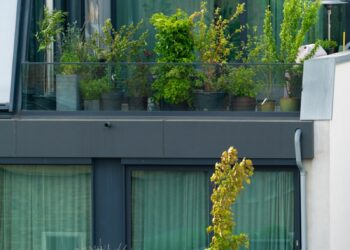 an apartment building with a balcony with plants on the balconies