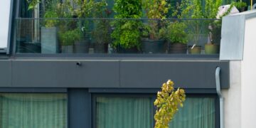 an apartment building with a balcony with plants on the balconies