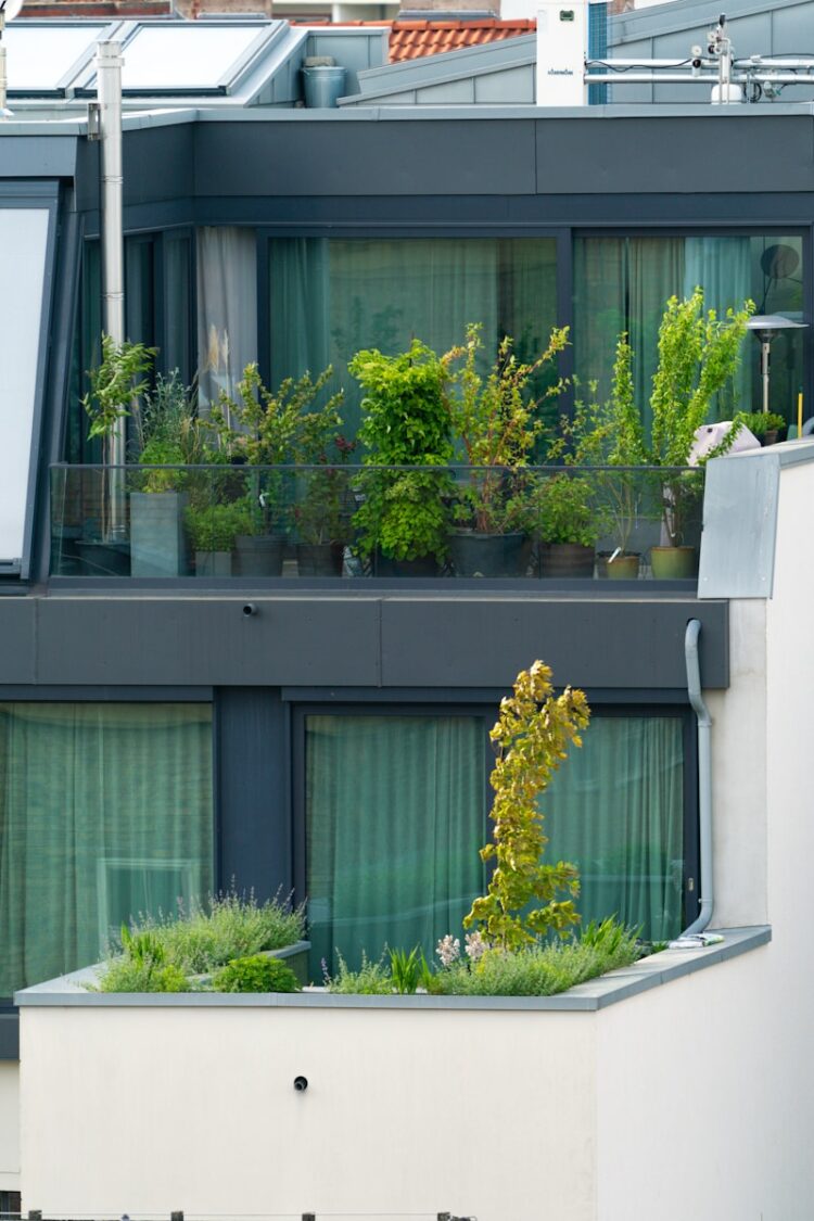an apartment building with a balcony with plants on the balconies