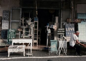two men sitting in front of table beside assorted wall decors store