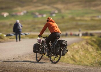 a man riding a bike down a dirt road