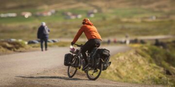 a man riding a bike down a dirt road