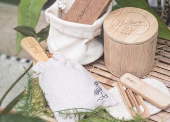 a bamboo table topped with wooden utensils and a bag