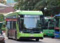 A bright green electric bus parked at a station.