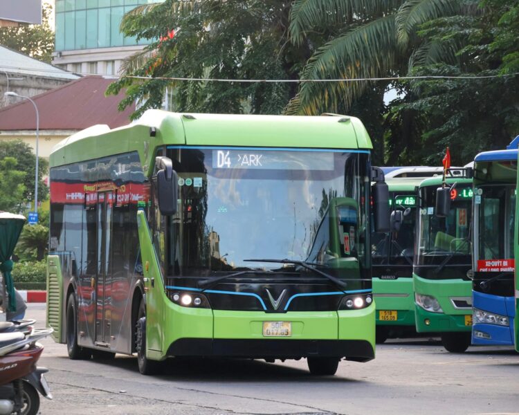 A bright green electric bus parked at a station.