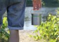 person in blue denim jeans holding stainless steel bucket