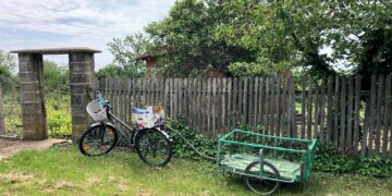 a bike parked next to a wooden fence
