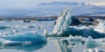 a group of icebergs floating on top of a body of water
