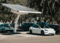 Electric car parked at a solar charging station outdoors, highlighting renewable energy and innovation.