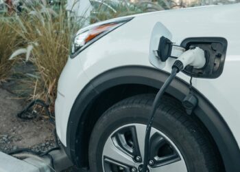 Close-up of an electric vehicle charging at a station, promoting clean energy.